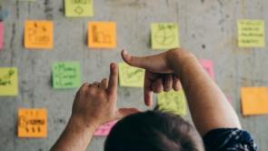 man looking at a bord of postits